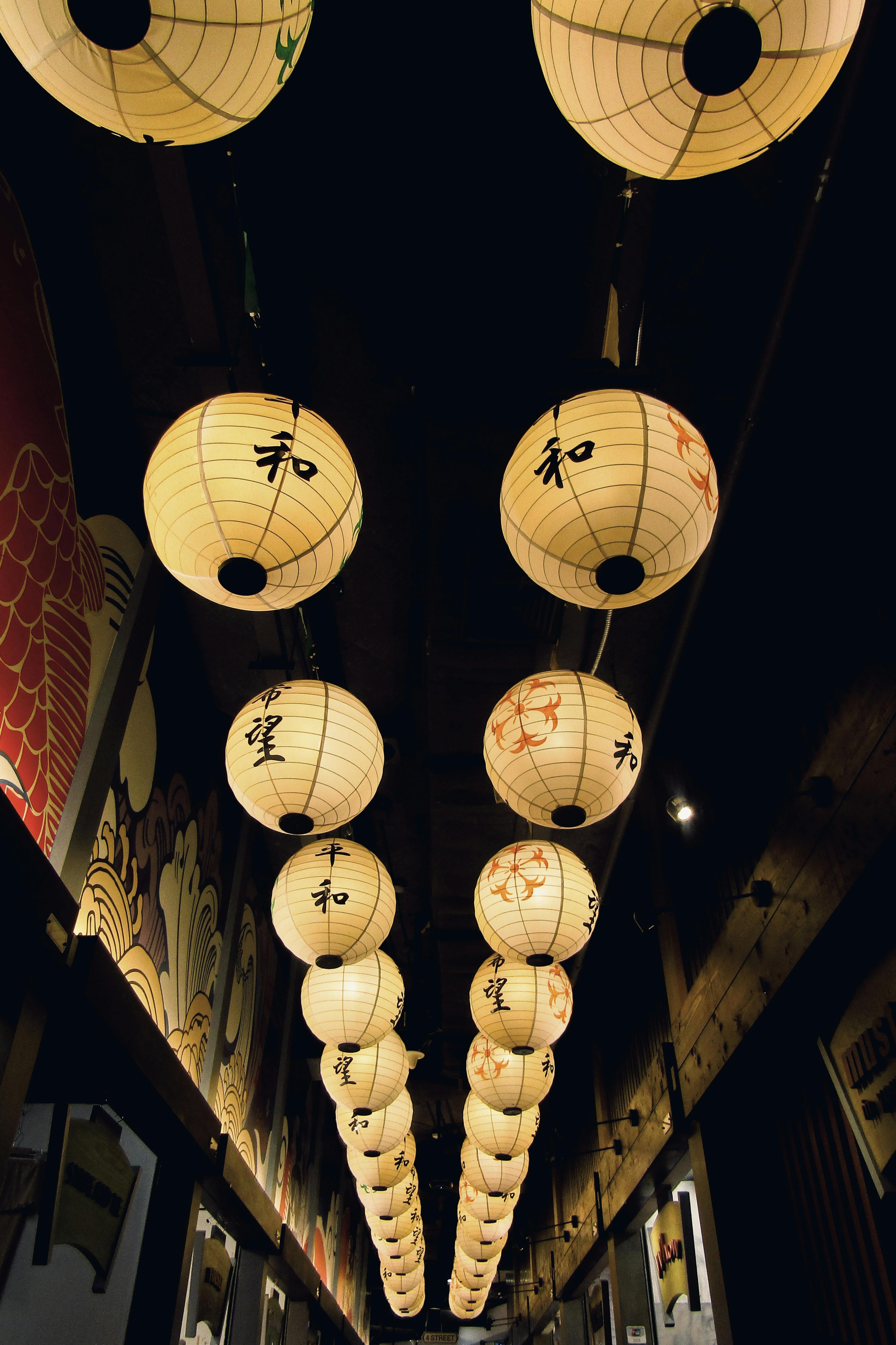 Japanese paper lanterns hanging in a narrow alleyway at night