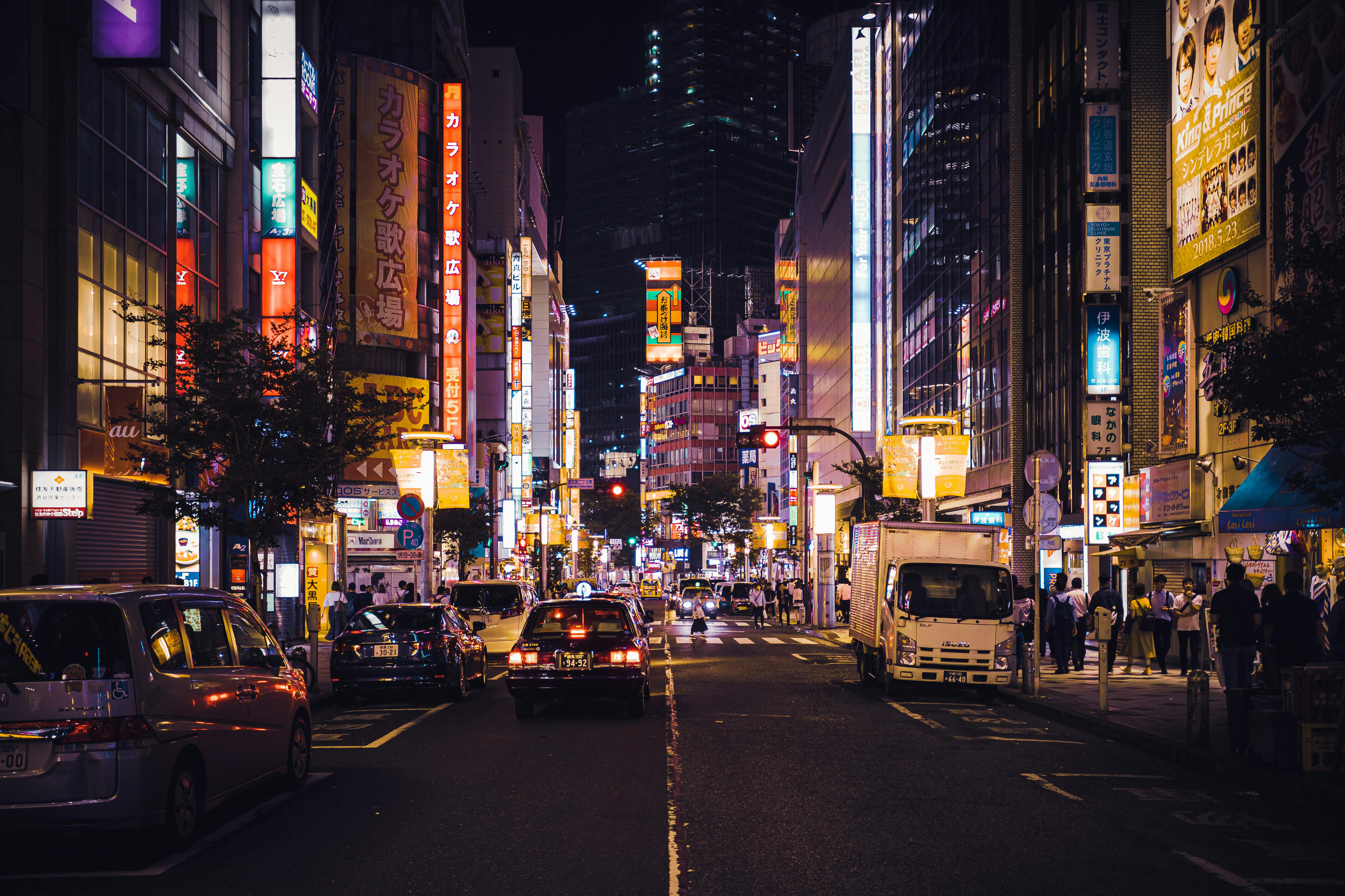 Glowing neon-lit street in Tokyo with pedestrians at night