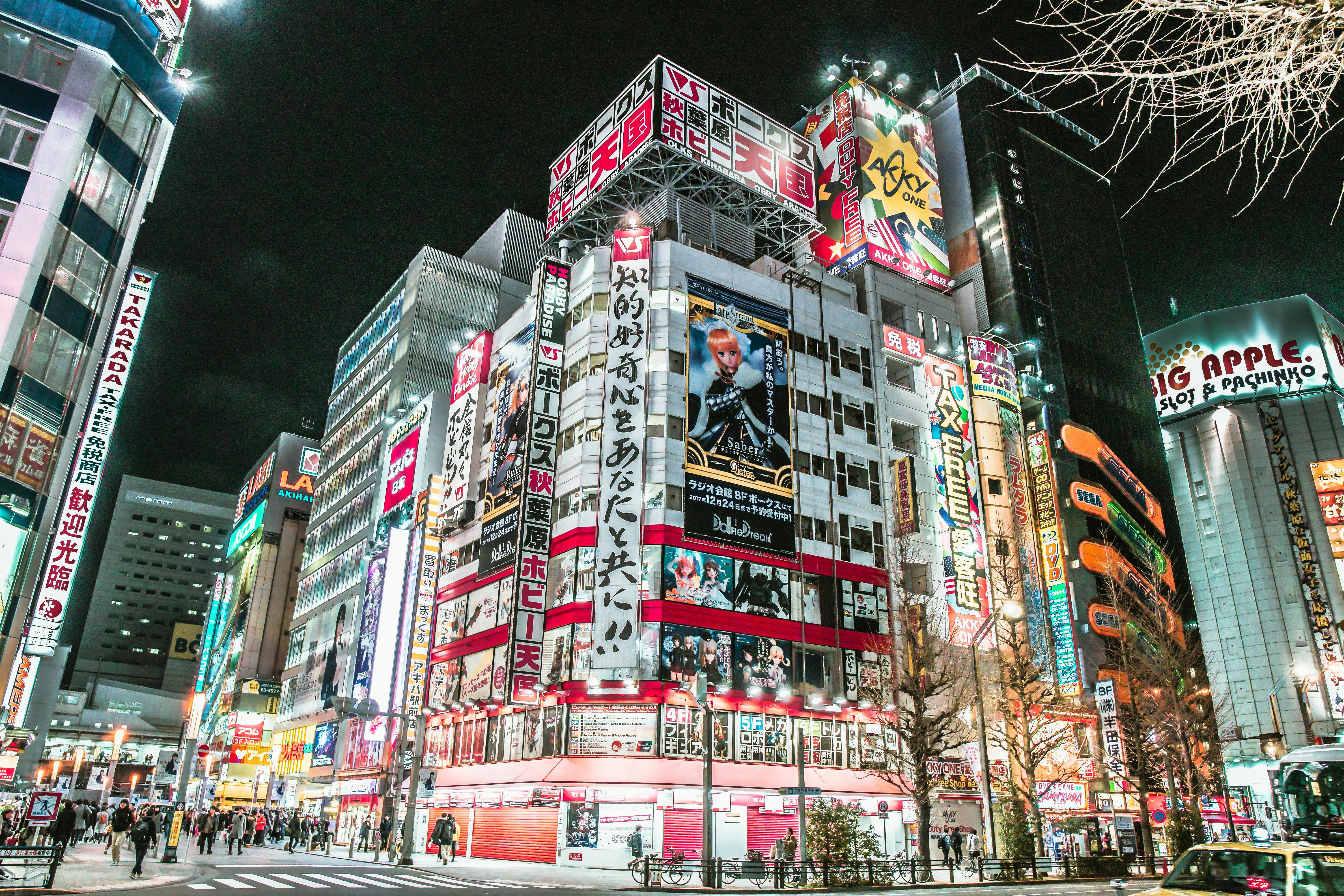 Akihabara at night with bright neon signs and anime billboards