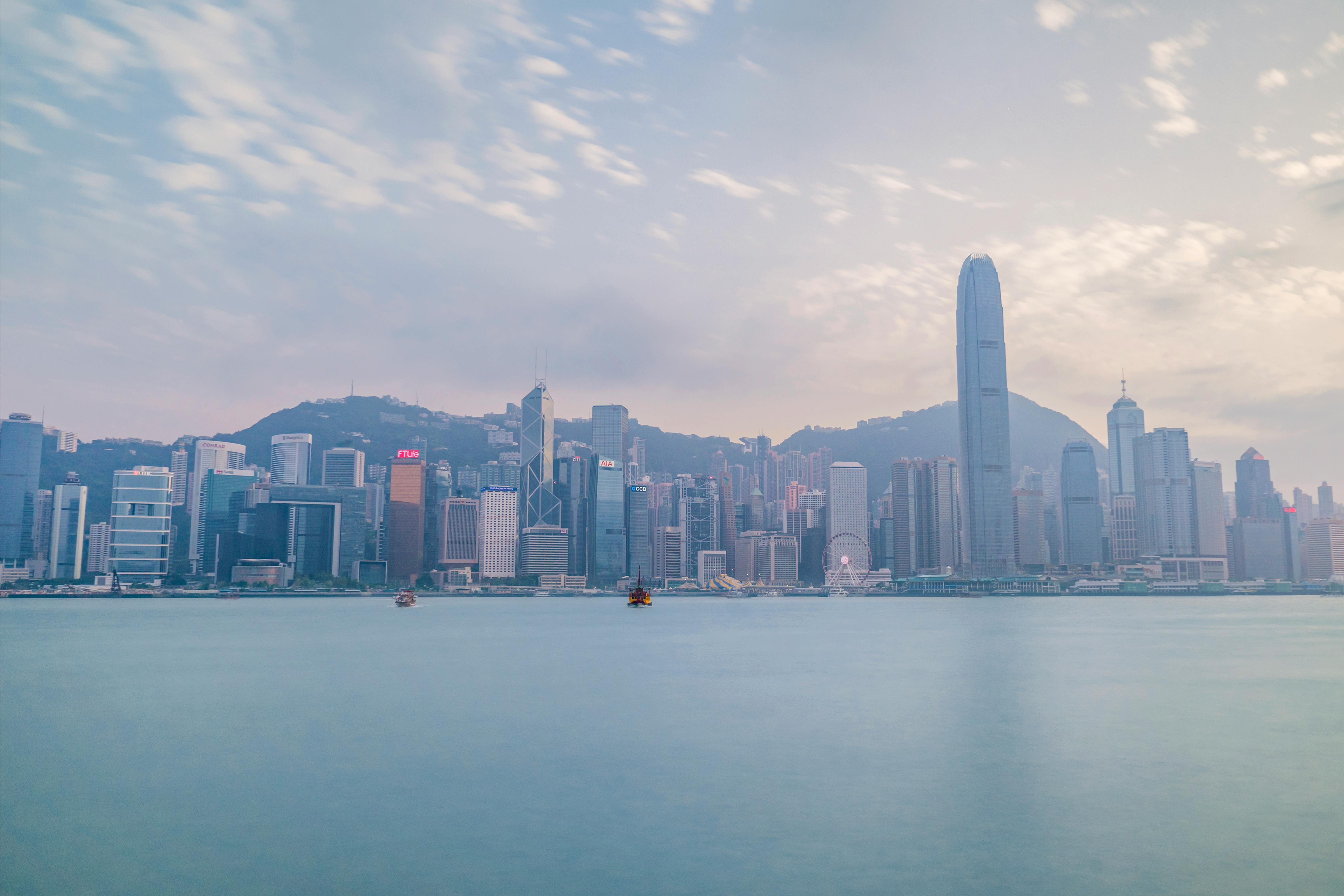 Hong Kong skyline, including the International Commerce Centre, viewed from across the calm water of Victoria Harbour